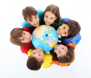 Kids holding together a terrestrial globe.